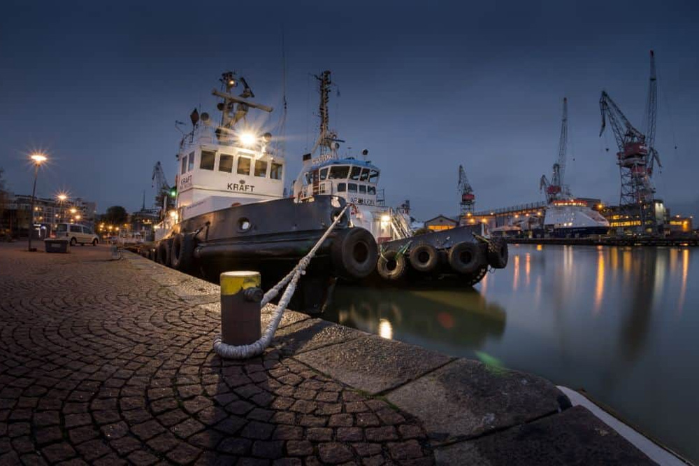Boat in harbour with navigation lights shinning onto dock