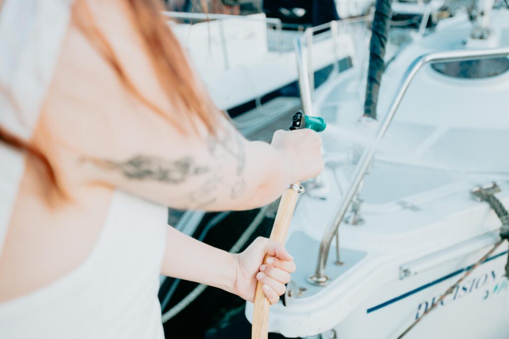a-young-cheerful-woman-cleaning-a-classic-sailing-2026-01-05-05-42-49-utc (1) Woman cleaning her boat using essential boat cleaning product