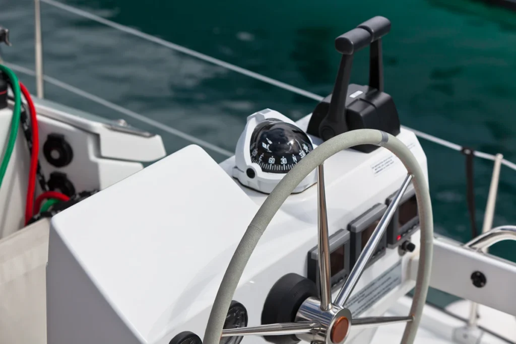 boat-steering-wheel-and-compass-on-the-ocean-2026-03-16-04-30-32-utc A boat steering wheel with cables