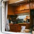 A caravan kitchen thorugh a window, with a stove and cooking utensils, two caravan must-haves