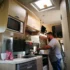 Man cooking on a stove in a caravan, essential equipment for a motorhome