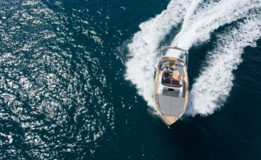 man-navigating-boat-on-a-sunny-ocean-day-2026-03-17-05-05-04-utc A boat leaning to one side on plane