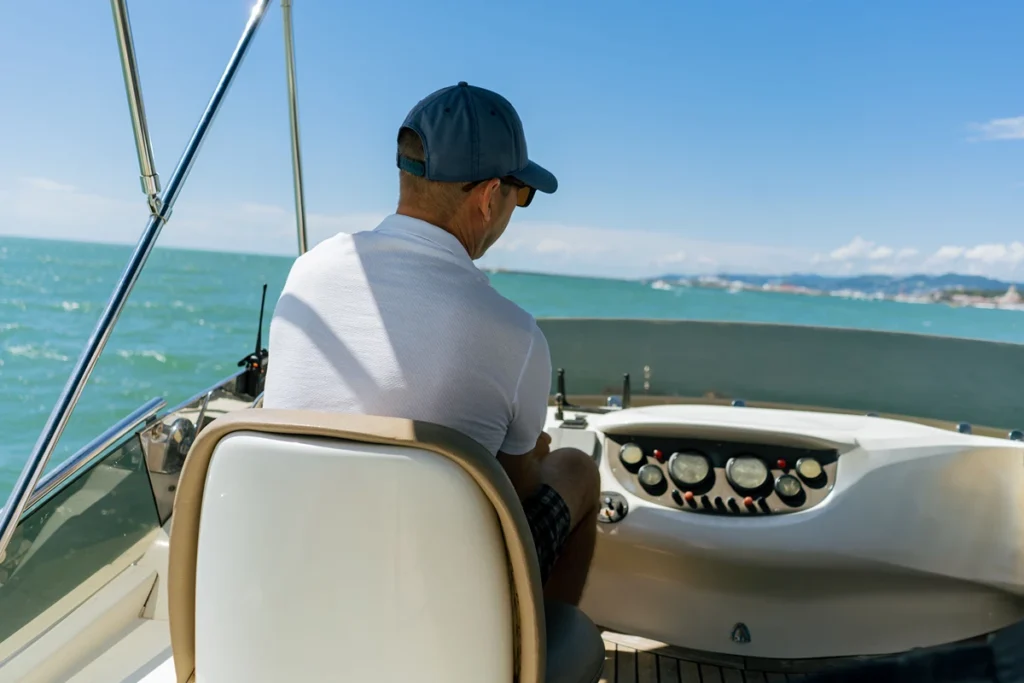 man-steers-boat-over-the-water-on-sunny-day-2026-03-19-23-41-49-utc Man steering a boat in a low-back boat seat
