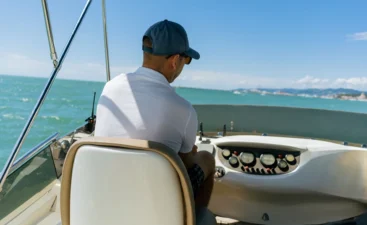man-steers-boat-over-the-water-on-sunny-day-2026-03-19-23-41-49-utc Man steering a boat in a low-back boat seat