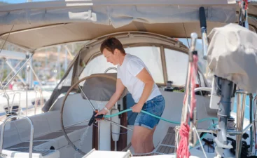 Woman washing boat with onboard water supply, pressurised with a water pump