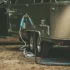 A caravan with water hoses connected to its water system, which is pressurised with water pumps